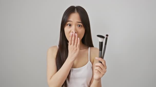 年轻的中国女人在震惊中 用手捂住嘴害怕化妆失误 白底捕捉到惊讶的表情 — 图库视频影像