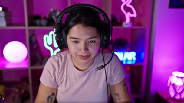 Hispanische Frau Mit Kopfhörer Leidet Nachts Einem Neonbeleuchteten Spielzimmer Unter — Stockvideo