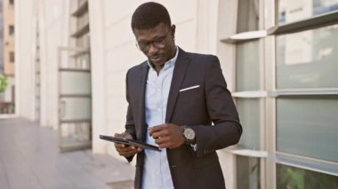 Şehir caddesinde tablet kullanan Afrikalı işadamı