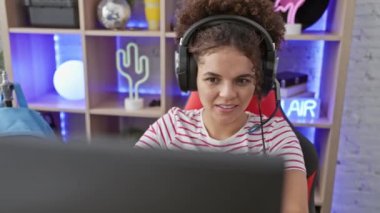 Kıvırcık saçlı, kendine güvenen İspanyol kadın büyüleyici bir şekilde gülümsüyor, arsız bir şekilde işaret veriyor parmaklarıyla gecenin bir yarısı neşe dolu oyun odasına bakıyor.