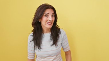 Gülen, orta yaşlı İspanyol kadın sulu dedikoduları dinliyor, baştan sona, güneşli sarı arka planda, izole edilmiş, sağırlıkla mücadele ediyor.