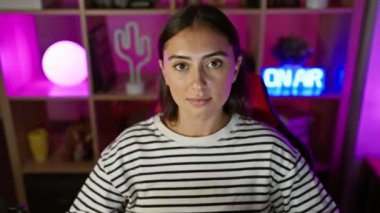 İspanyol kadın evdeki neon ışıklı oyun odasında kulaklıklarını ayarlıyor..