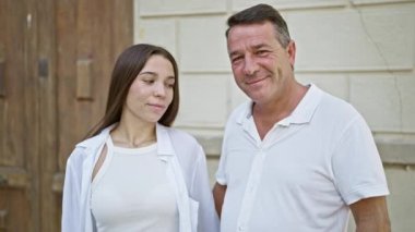 Kendine güveni tam bir baba, güneşli bir şehir caddesinde kızıyla samimi ve güler yüzlü bir kucaklaşmayı paylaşıyor. Mutlu, sıradan yaşam tarzları, açık havada sevgi ve neşe saçıyor..