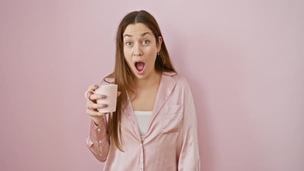 Lenyűgöző Kék Szemű Fiatal Pizsamában Kávéscsészében Hitetlenkedő Szájjal Elszigetelt Rózsaszín — Stock videók