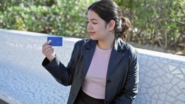 Egy Vidám Fiatal Spanyol Bőrdzsekiben Megvizsgál Egy Hitelkártyát Szabadban Egy — Stock videók