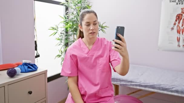 Jonge Vrouw Roze Scrubs Met Behulp Van Smartphone Voor Video — Stockvideo