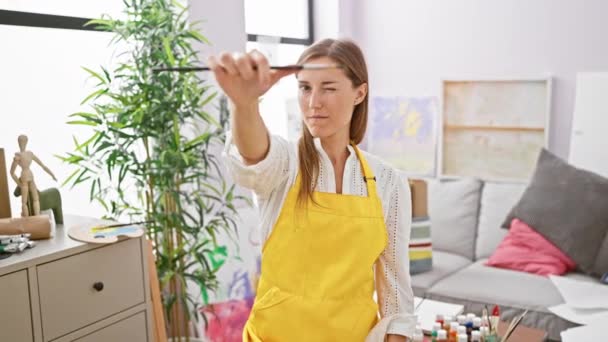 Cheerful Woman Artist Yellow Apron Examines Her Paintbrush Bright Art — Stock Video