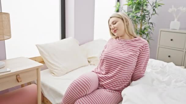 リラックスした若い女性が彼女の明るい寝室でラウンジし 自宅でカジュアルな快適さを体現 — ストック動画