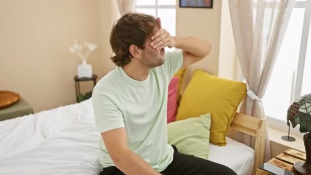 Straszny Młody Mężczyzna Piżamie Ukrywa Oczy Dłońmi Sypialni Sygnalizując Zatrzymanie — Wideo stockowe