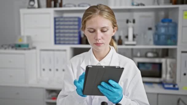 Une Jeune Femme Concentrée Blouse Laboratoire Examine Une Tablette Entourée — Video