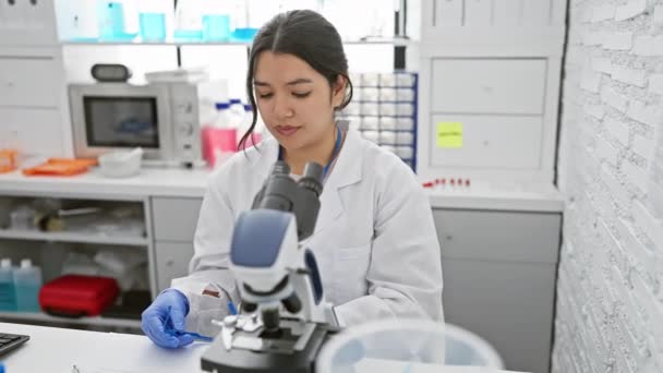 Une Scientifique Hispanique Focalisée Examine Des Échantillons Microscope Dans Laboratoire — Video