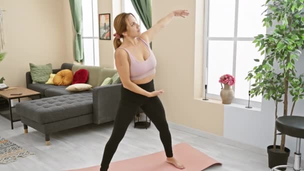 Ung Kvinna Utövar Yoga Inomhus Ett Mysigt Vardagsrum Visar Välbefinnande — Stockvideo