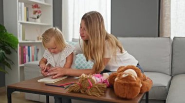 Kafkas anne ve kızı bir deftere çizim yaparken rahatlıyor, oturma odalarının konforunda alkışlıyor ve alkışlıyorlar, neşeli alkışlarla dolu evleri.