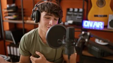 Genç İspanyol erkek enstrümanı ve kendine güvenen bir gülümseme ile müzik stüdyosundaki ses cennetinde kaybolurken tutkuyla en sevdiği şarkıyı söylüyor.