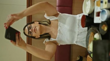 Güzel İspanyol kadın şık bir restoranda nefis bir yemek fotoğrafı çekiyor, bir kafe yemek yaşam tarzı portresi.