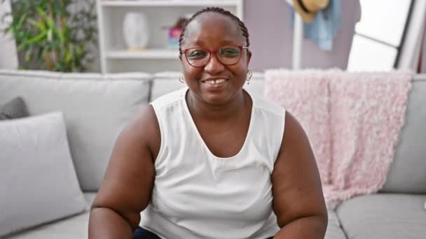 自信的非洲裔美国女人 留着辫子 快乐地微笑着 在家里炫耀她那有力的手臂姿势 — 图库视频影像