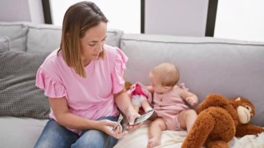 Evde, koltukta, kendinden emin bir anne, oyuncak bebeklerle oynarken kızının güzel çocukluğuna yatırım yaparak dolarları sayar.