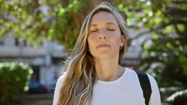 Sakin, sarışın bir kadın açık hava manzarasının ortasında huzurlu bir anın tadını çıkarıyor..