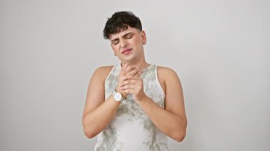 Kolsuz tişört giyen genç bir adam, beyaz arka planda acı çeken bir el ve parmak ağrısı ile boğuşuyor. Artrit iltihabı belirgin, yürek parçalayıcı bir görüntü..