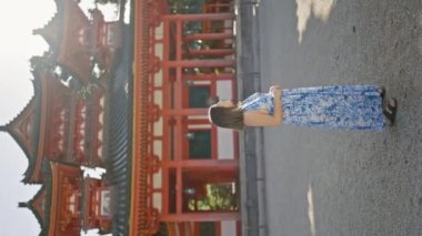 Güzel İspanyol kadın ayakta duruyor, eğleniyor ve gülümsüyor geleneksel jingu jingu türbesine bakarken, kyoto, japan
