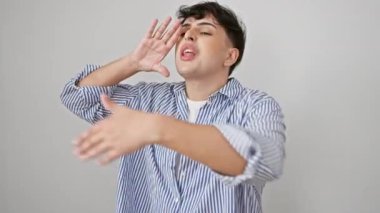 Çizgili tişörtlü şaşkın genç bir adam, kolları açık, bilmediğimiz bir şekilde suratında duruyordu. beyaz arkaplanda izole edilmiş