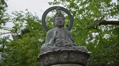 Huzurlu Japon Buda heykeli huzur ve maneviyatı sembolize eden sakin bir bahçede..
