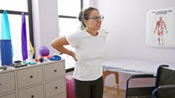 Volwassen Latino Vrouw Met Bril Ervaren Rugpijn Een Fysiotherapie Kliniek — Stockvideo
