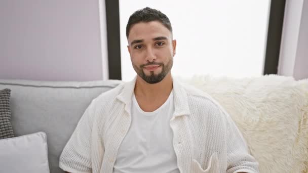 Alegre Joven Árabe Sentado Despreocupado Sofá Casa Presentando Con Entusiasmo — Vídeo de stock