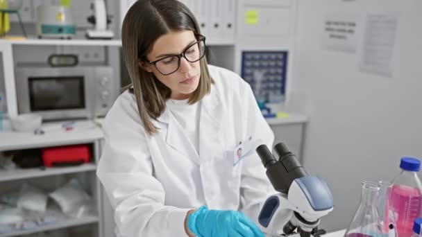 Focused Hispanic Woman Working Microscope Modern Laboratory Setting Depicting Professionalism — Stock Video