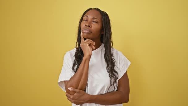Mujer Afroamericana Adulta Con Pelo Rizado Pensando Contra Pared Amarilla — Vídeo de stock