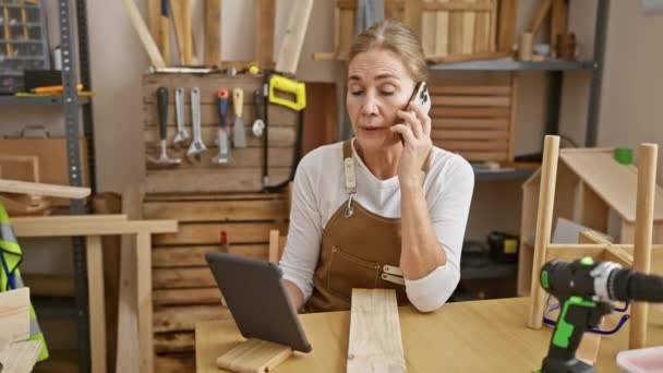 Focused Middle Aged Woman Speaking Phone Surrounded Woodworking Tools Furniture — Stock Video