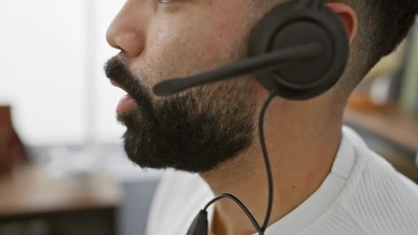 ヘッドセット付きのひげ付き男のクローズアップ 近代的なオフィスの設定で通信 — ストック動画