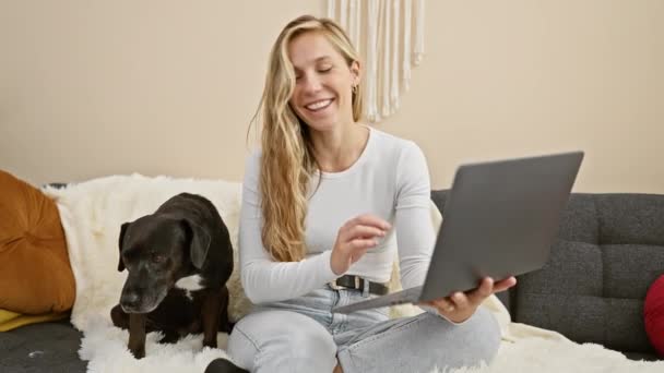 Uśmiechnięta Kobieta Siedzi Czarnym Labradorem Przytulnym Salonie Pracując Nad Laptopem — Wideo stockowe