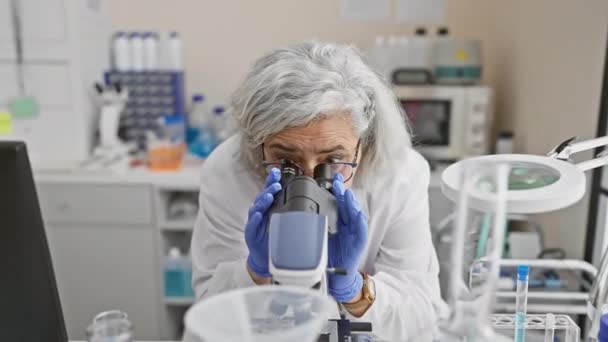 Uma Cientista Madura Examina Amostras Com Microscópio Ambiente Laboratorial — Vídeo de Stock