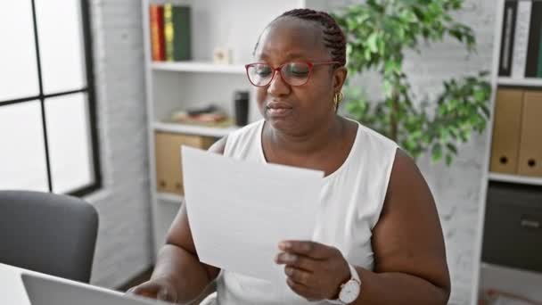 Εστιασμένη Αφροαμερικανίδα Επιχειρηματίας Που Διαβάζει Έγγραφο Laptop Στο Γραφείο Δουλεύοντας — Αρχείο Βίντεο