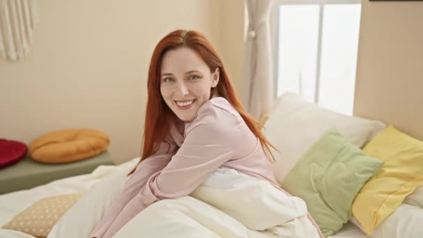 Μια Χαμογελαστή Νεαρή Καυκάσια Γυναίκα Ξαπλωμένη Στο Κρεβάτι Επιδεικνύοντας Ένα — Αρχείο Βίντεο