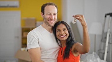 Yeni evin anahtarlarını tutan güzel bir çift.