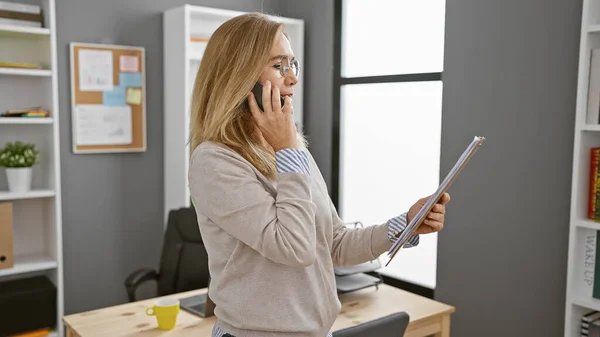 Mature Caucasian Woman Talking Phone While Holding Documents Modern Office — Stock Photo, Image