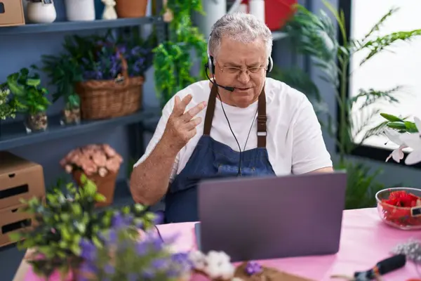 灰色の髪の男性 花屋でビデオ通話を持っている花屋 — ストック写真