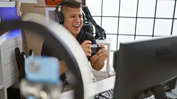 Smiling latin streamer, a young man\'s live video call during an exciting gaming session in his music studio