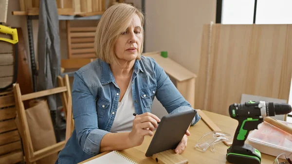 Mature Caucasian Woman Workshop Using Tablet Amidst Carpentry Tools — Stock Photo, Image