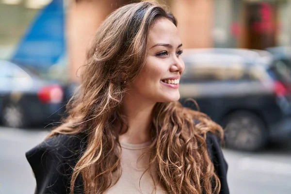 Young beautiful hispanic woman smiling confident looking to the side at street