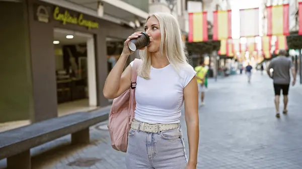 若い金髪の女性が飲む ストリートでコーヒーのカップを取る — ストック写真