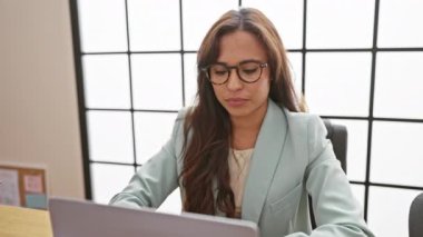 Kendine güvenen İspanyol iş kadını, çekici, ofis işini gülümseyerek bitiriyor, akıllı telefondan başarı mesajı yolluyor.