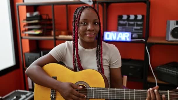 Sorrindo Afro Americana Toca Uma Melodia Clássica Sua Guitarra Interior — Vídeo de Stock