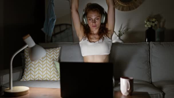Mladá Žena Sluchátkách Protáhne Zatímco Pracuje Pozdě Notebooku Svém Obývacím — Stock video