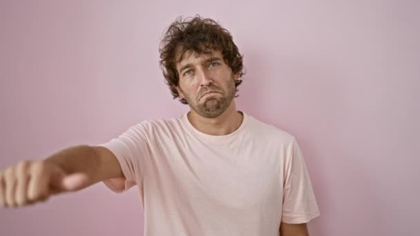 ピンクの壁に親指を与え 否定的な意見や不満を表現するカーリーな髪の不満の若者 — ストック動画