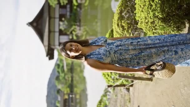 美しいヒスパニックの女性が喜びを放射し 自信を持って立って 日本の伝統的な京都で平安神宮に歩いている間にカメラに微笑みました — ストック動画