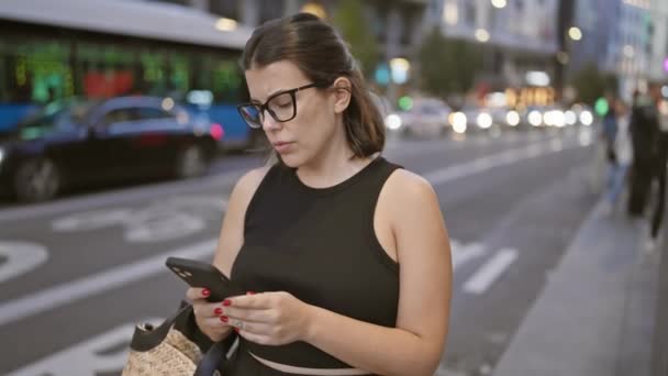 Όμορφη Νεαρή Ισπανίδα Γυναίκα Φορώντας Γυαλιά Χρησιμοποιώντας Smartphone Περιμένει Ταξί — Αρχείο Βίντεο