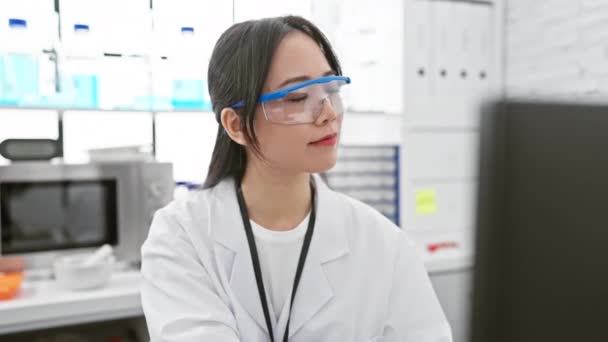快乐的年轻中国女科学家 带着好奇的目光 面带微笑 迷茫在实验室的旁边 流露出自信和信任 — 图库视频影像